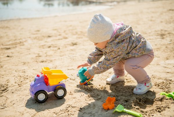 Baby spielt im Sand